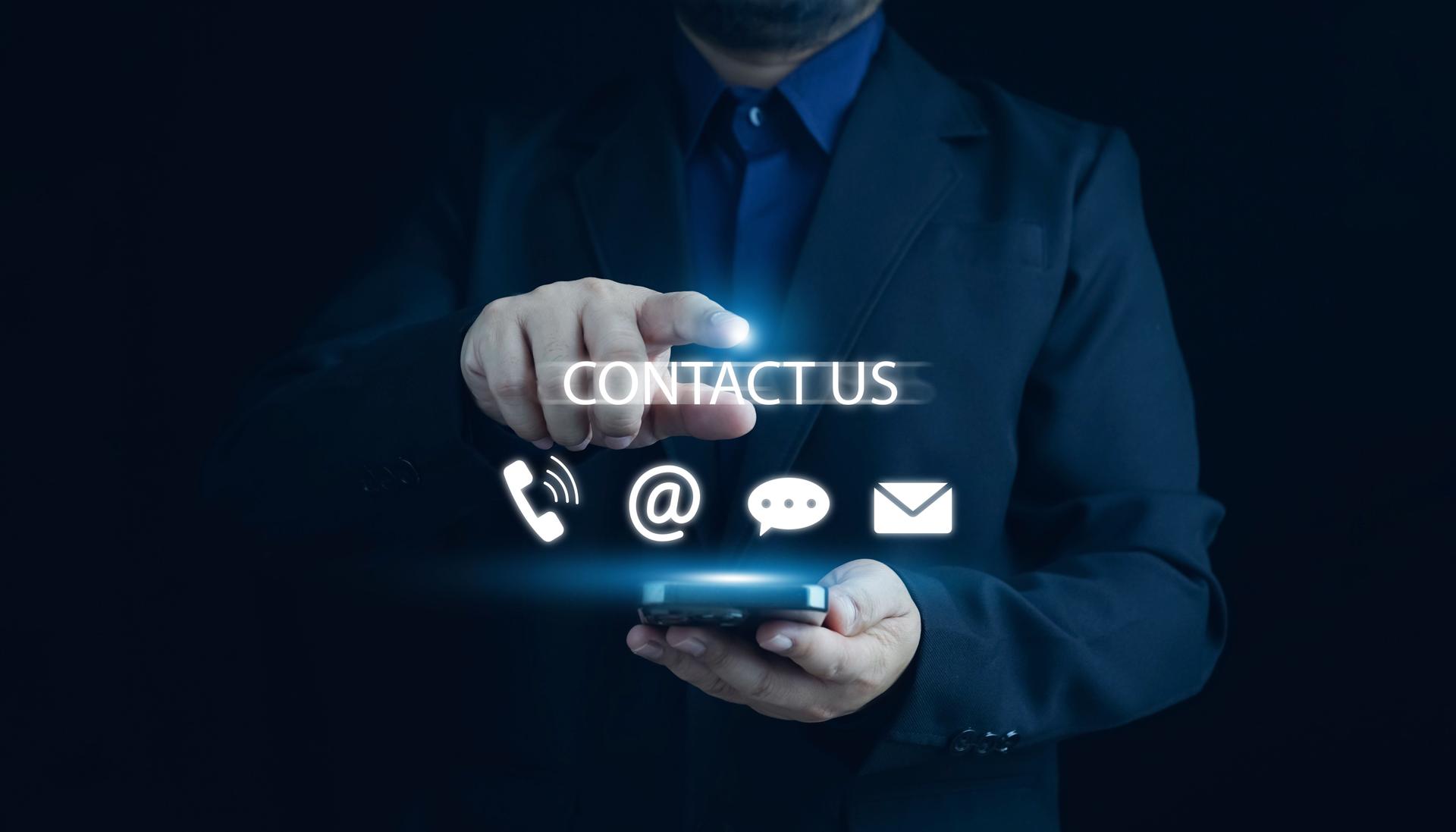 Contact us or Customer support hotline, people connect. Businessman touching on virtual screen contact icons (email, address, live chat, telephone). Customer service, helpdesk advice online support.