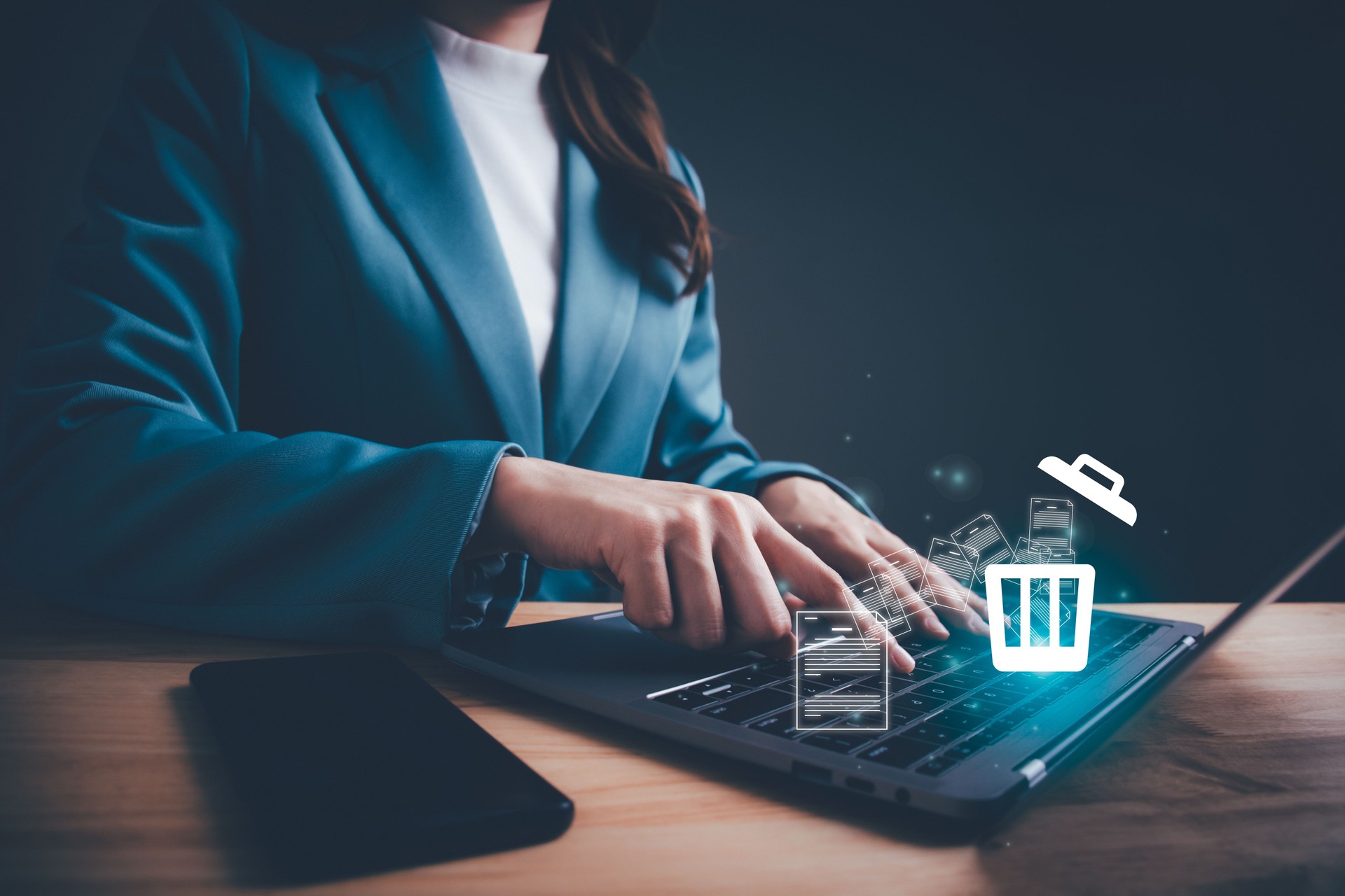 Businesswoman using computer laptop or smartphone delete files  from a computer or from the Internet. Concept of deleting files, contacts, putting in order, cleaning service, trash can and files.